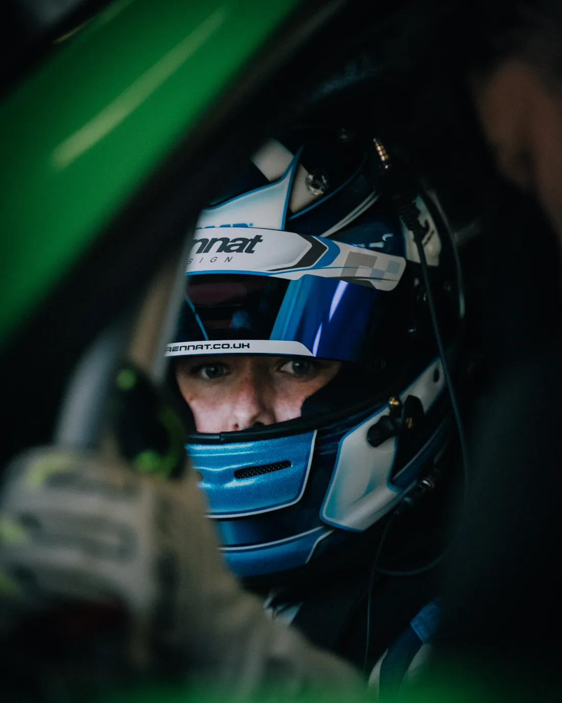 Chloe Grant in the car with her helmet on, seen through the window